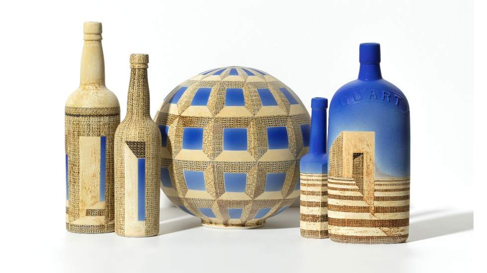 Five ceramic vessels painted in blue and cream, with geometric patterns.
