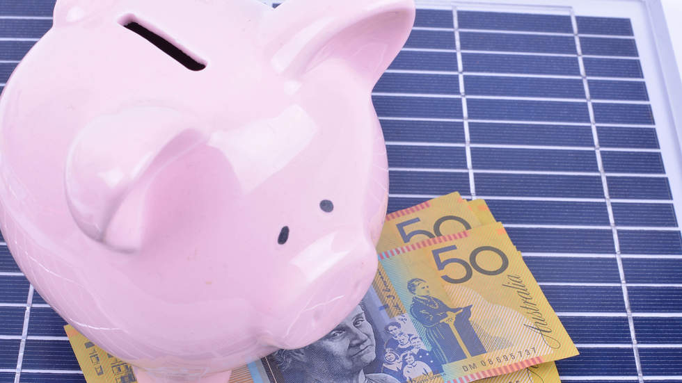 Pink piggy bank on solar panel with $50 bills