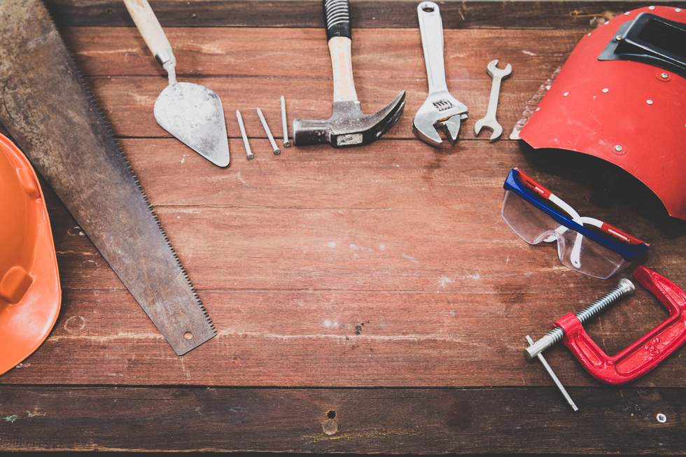 Several tools spread out on a timber bench. 