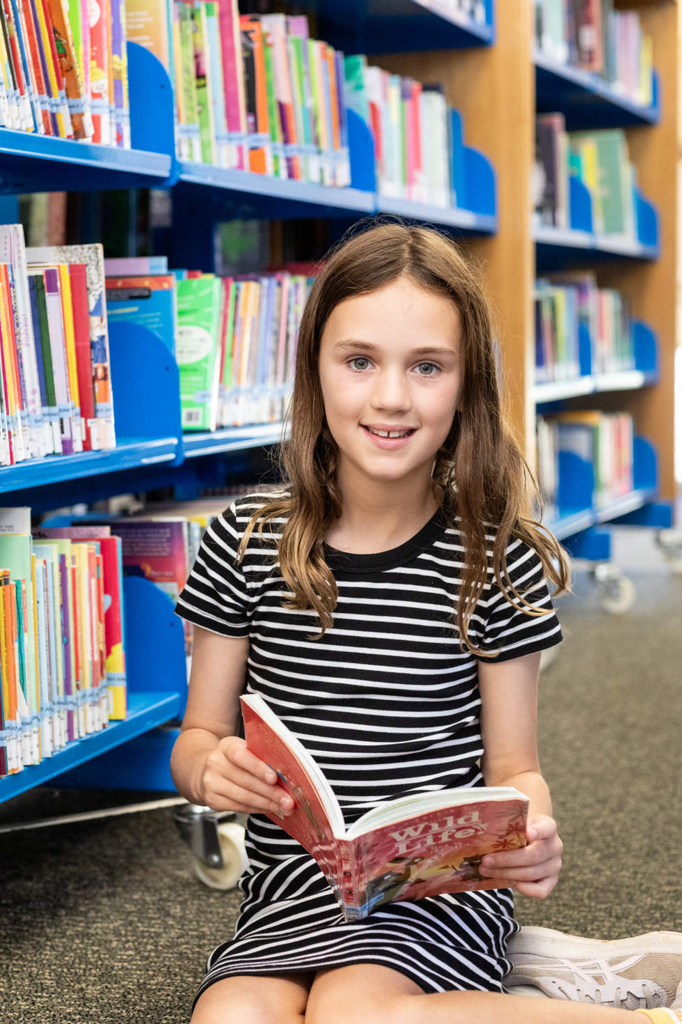 A young girl reading a book in Beaumaris library 