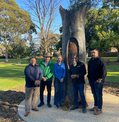 Five people standing in front of Sovereign Tree sculpture