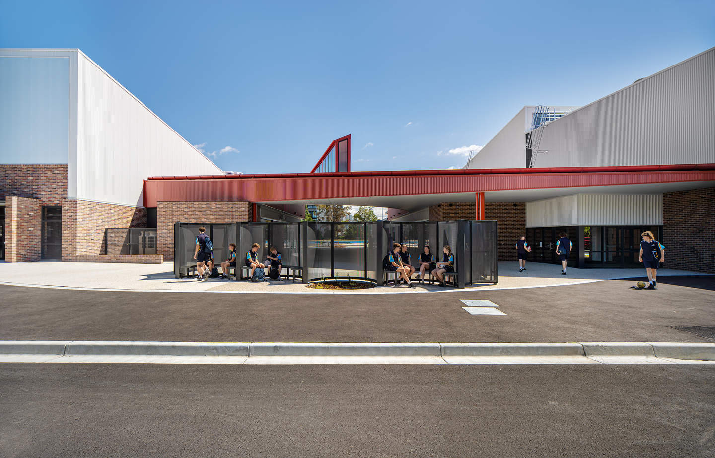 Entrance of new netball centre with kids on benches.