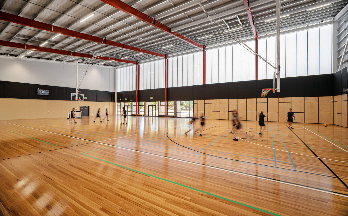 Inside netball centre with kids playing netball.