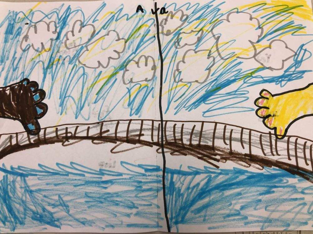 Childs drawing of two hands about hold over a bridge with clouds.