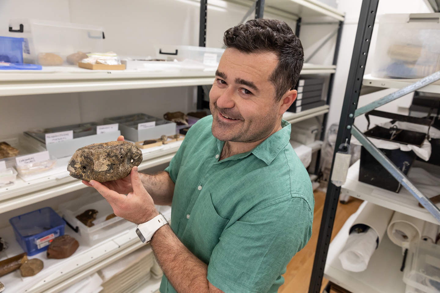 Palaeontologist Ben Francischell holding a prehistoric fossil 