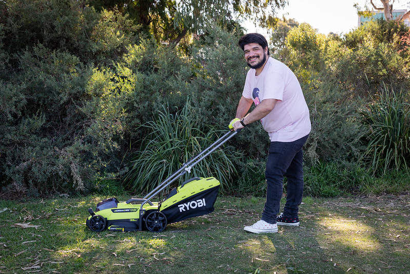  A person using an electric lawnmower 