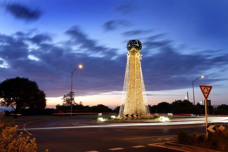 strings of Christmas lights draped down Black Rock clock tower at night