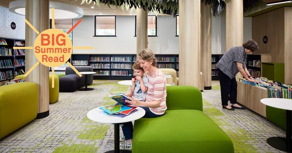 Woman and child sitting in library reading