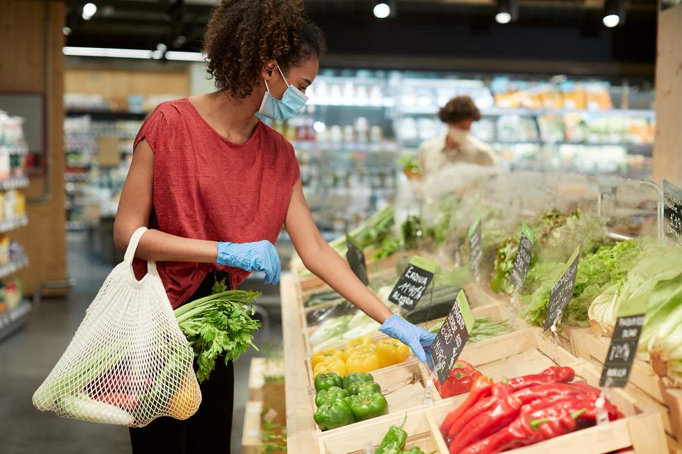 woman shopping for loose veg with reusable bag