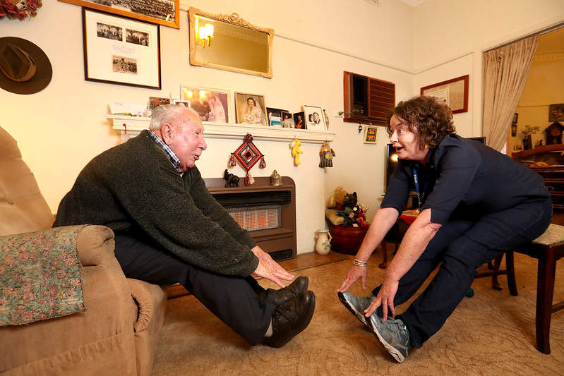 Aged care worker showing older resident how to have a good stretch