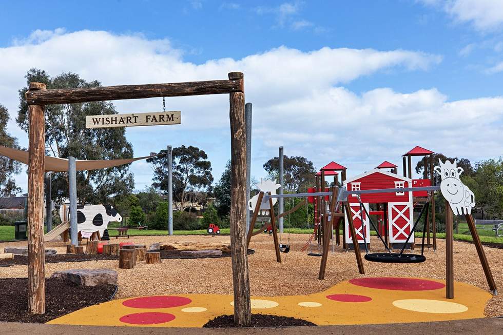 Farmyard style playground called Wishart Farm with a swing and barn playhouse in the background