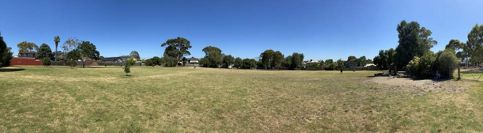panoramic view of wishart reserve with large grassed area and trees in the background