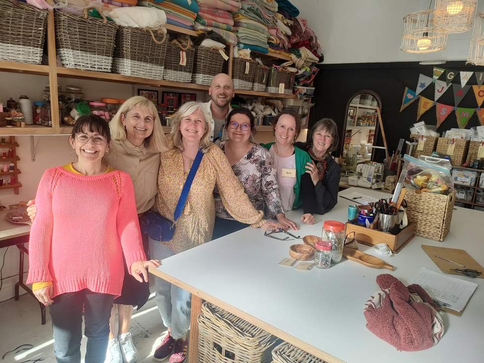 Group of happy people in sewing room.