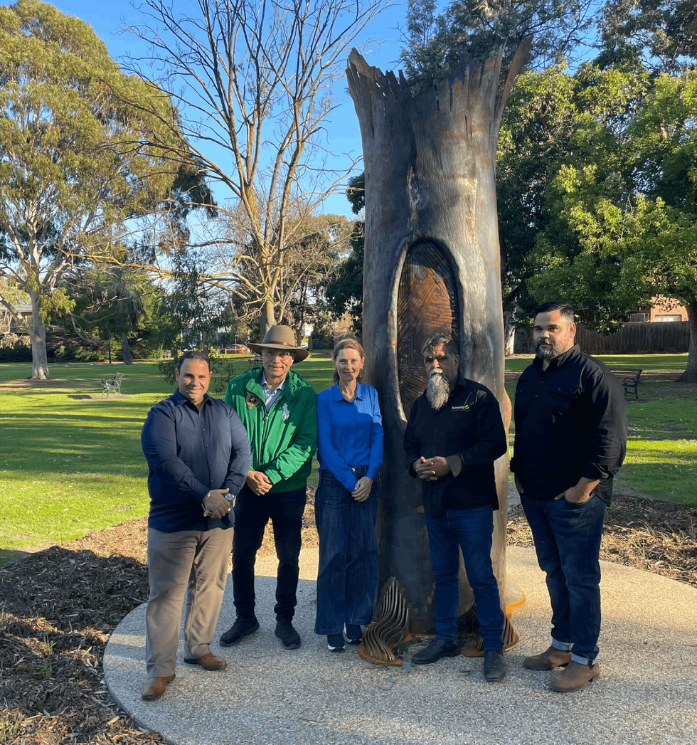 Five people standing in front of Sovereign Tree sculpture